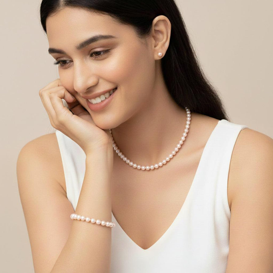 Customer smiling wearing a pearl strand and stud earrings